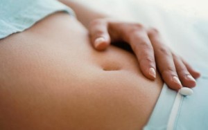 Žena dodiruje stomak